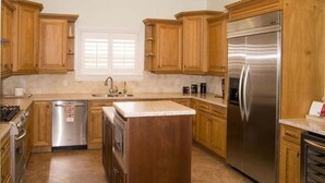 Una cucina con mobili in legno, un frigorifero in acciaio inossidabile e una lavastoviglie.