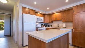 A modern kitchen with wooden cabinets, a white refrigerator, a microwave, a stove, and a dishwasher. - Not available now (Kelowna)