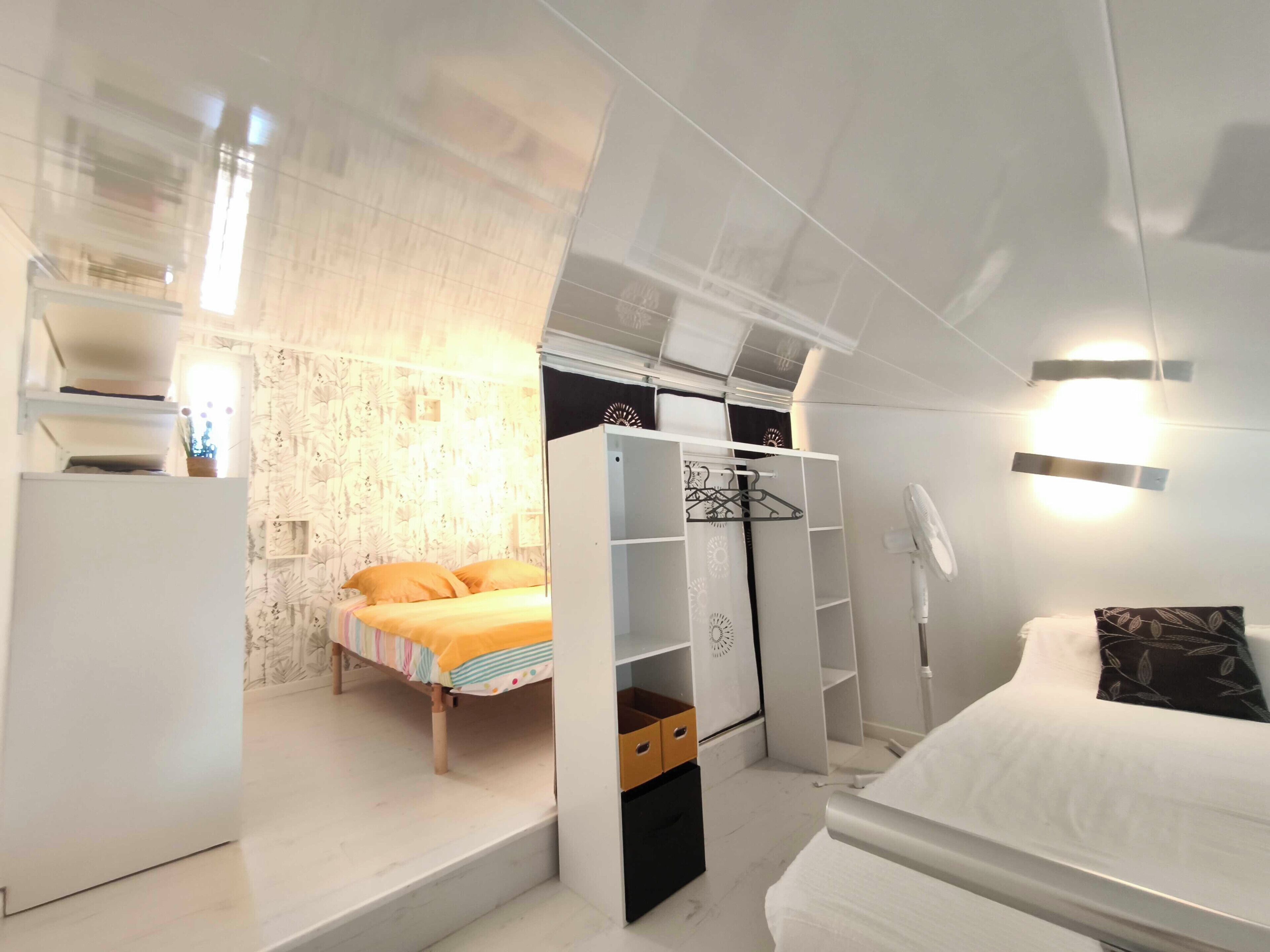 A bedroom with a bed, a wardrobe, and a nightstand.