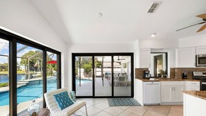 A modern kitchen with white cabinets, a microwave, and a coffee maker. - Seaside Villa Southern Belle - 3/2 Southeast paradise with spa and outside TV (Cape Coral)