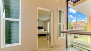 A corridor with a bed in the background, a glass door, and a balcony with a railing. - ComfyStudio w/QueenBed/Tijuana Near USBorder (Tijuana)