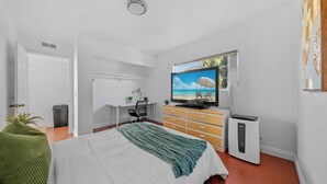 A bedroom with a bed, a TV, a dresser, and a heater. - Garage, Gated Yard, near SD Gaslamp, DT, 4BR/2Bth (National City)