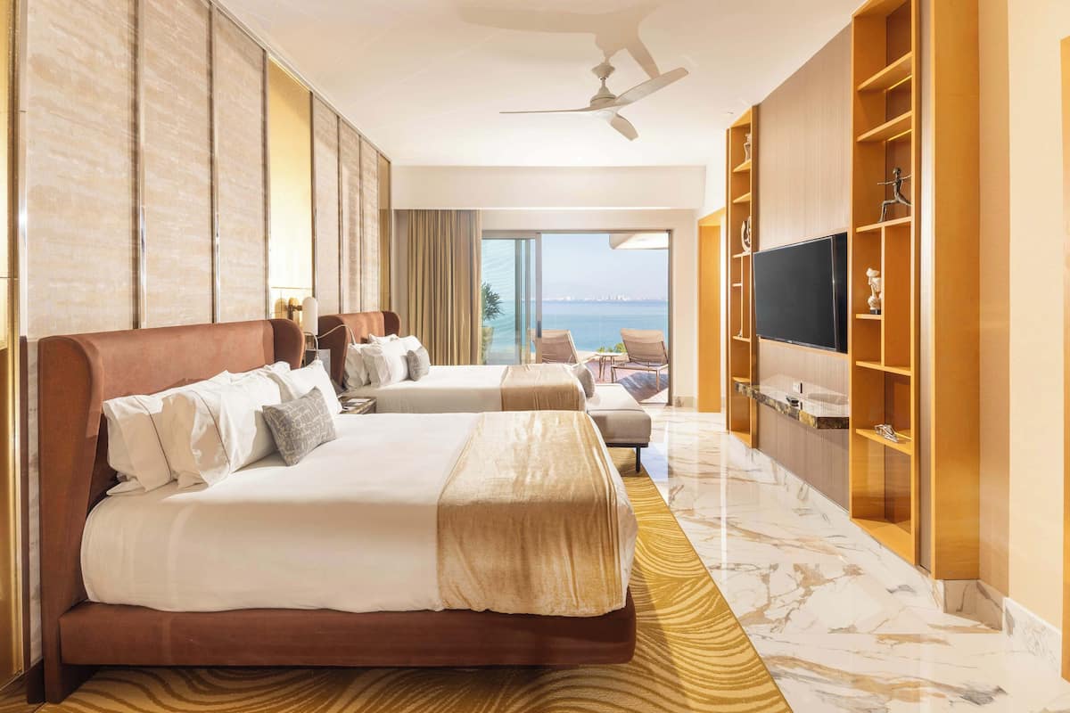 A hotel room with two beds, a television, a balcony with a view, and a marble floor.