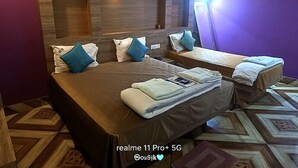 A hotel room with two beds, a wooden headboard, and a patterned floor. - HOTEL SHREESH NEIL (Port Blair)