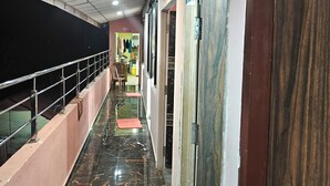 A corridor with a marble floor, metal railing, and doors leading to rooms. - HOTEL SHREESH NEIL (Port Blair)