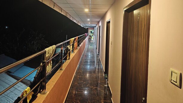 A corridor with a marble floor, a balcony with a railing, and a door on the right. - HOTEL SHREESH NEIL (Port Blair)
