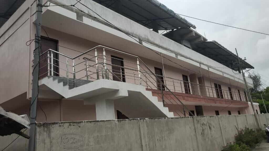 Ein zweistöckiges Gebäude mit Balkon und Treppe.
