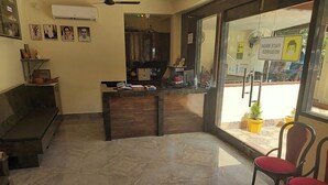 A reception area with a marble floor, a reception desk, a sofa, and two chairs. - HOTEL SHREESH NEIL (Port Blair)