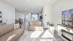 Una sala de estar moderna con un sofá, chimenea y televisor.
