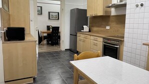 A compact kitchen with a dining area, a refrigerator, a stove, and a microwave. - Spacious 160 sqm apartment in central Göppingen for families, fitters, groups (Göppingen)