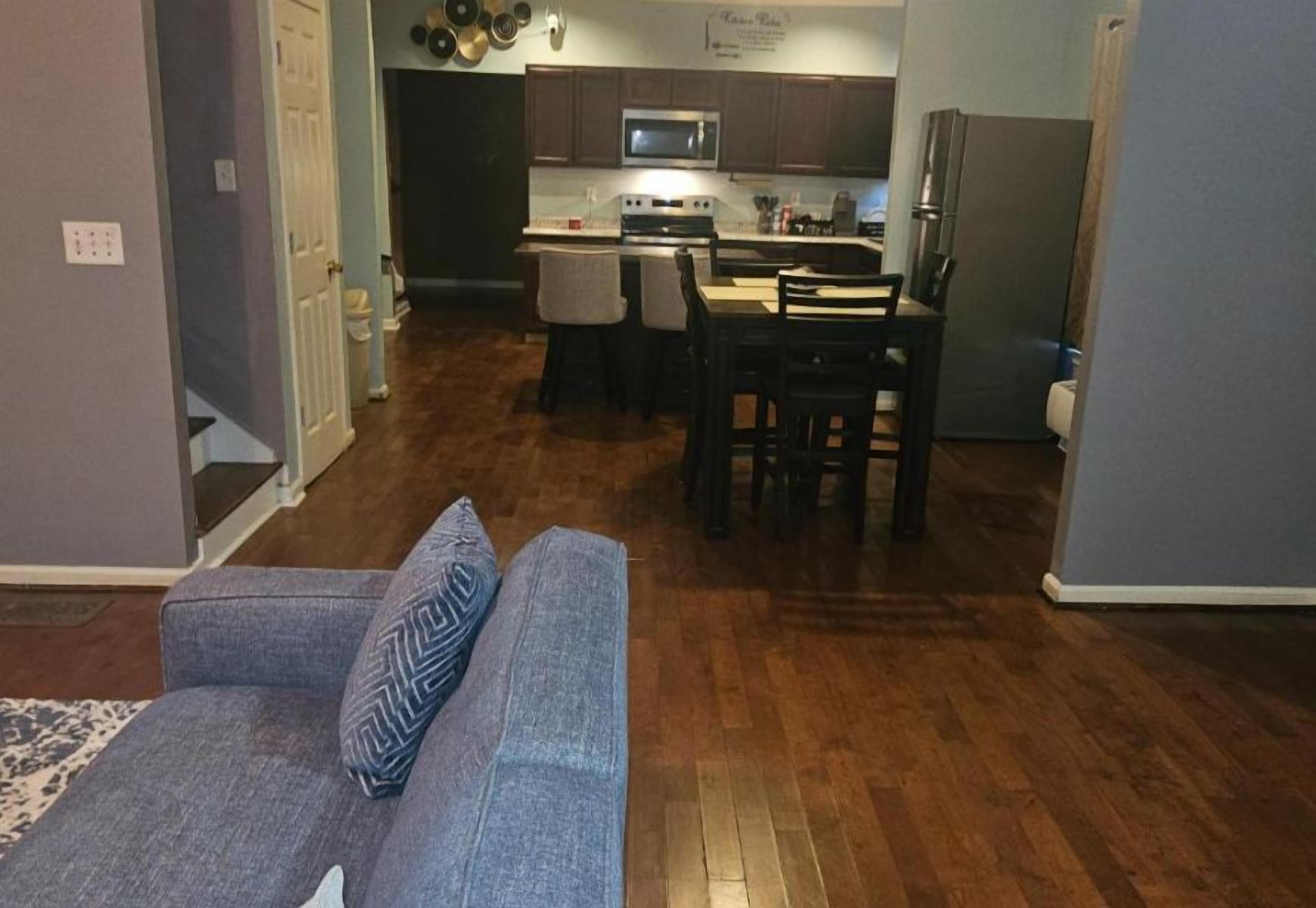 A living room with a sofa and a dining area with chairs and a table.