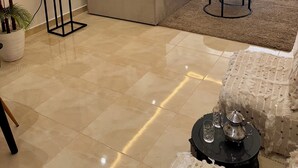 A modern living room with a sectional sofa, a round coffee table, and a potted plant. - Stylish & Cozy | Downtown 2BR Netflix+Fast Wifi•AC (rabat)