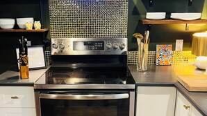 Una cocina moderna con estufa, horno de acero inoxidable y un salpicadero decorativo.