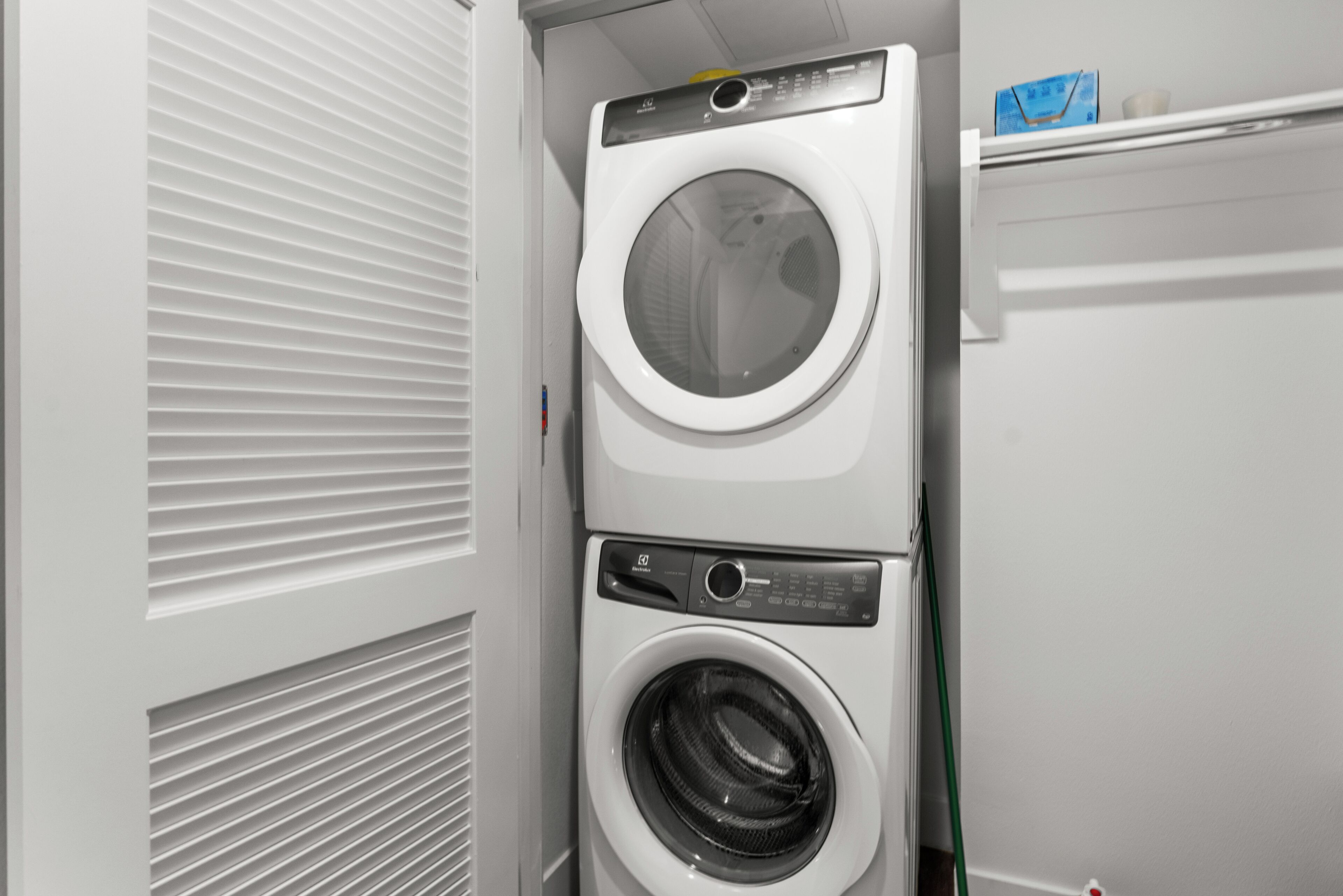 A stacked washer and dryer unit in a laundry room.