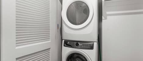 A stacked washer and dryer unit in a laundry room.