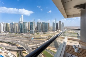 A high-rise building with a view of a cityscape, including multiple skyscrapers and a highway. - Elegant 1 Bedroom l Skyline Views l Dubai Marina (Dubai Marina)