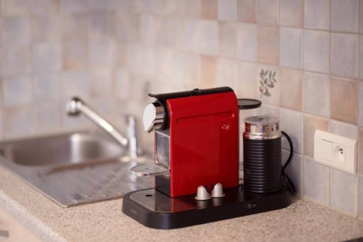 A kitchen with a coffee machine, a sink, and a power outlet.