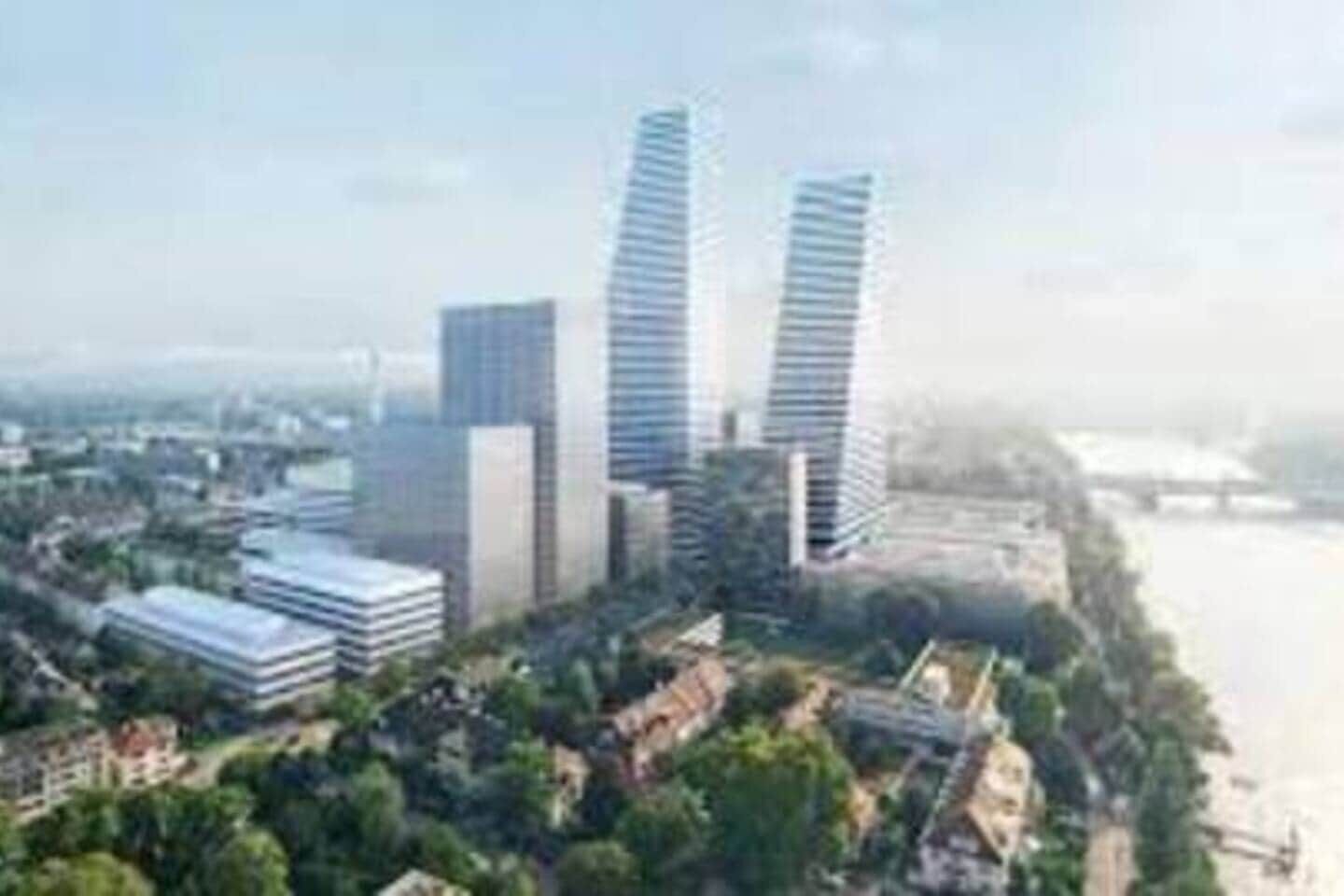 Ein moderner, hoch aufragender Gebäudekomplex mit mehreren Wolkenkratzern, umgeben von Grünflächen und einer Uferpromenade.