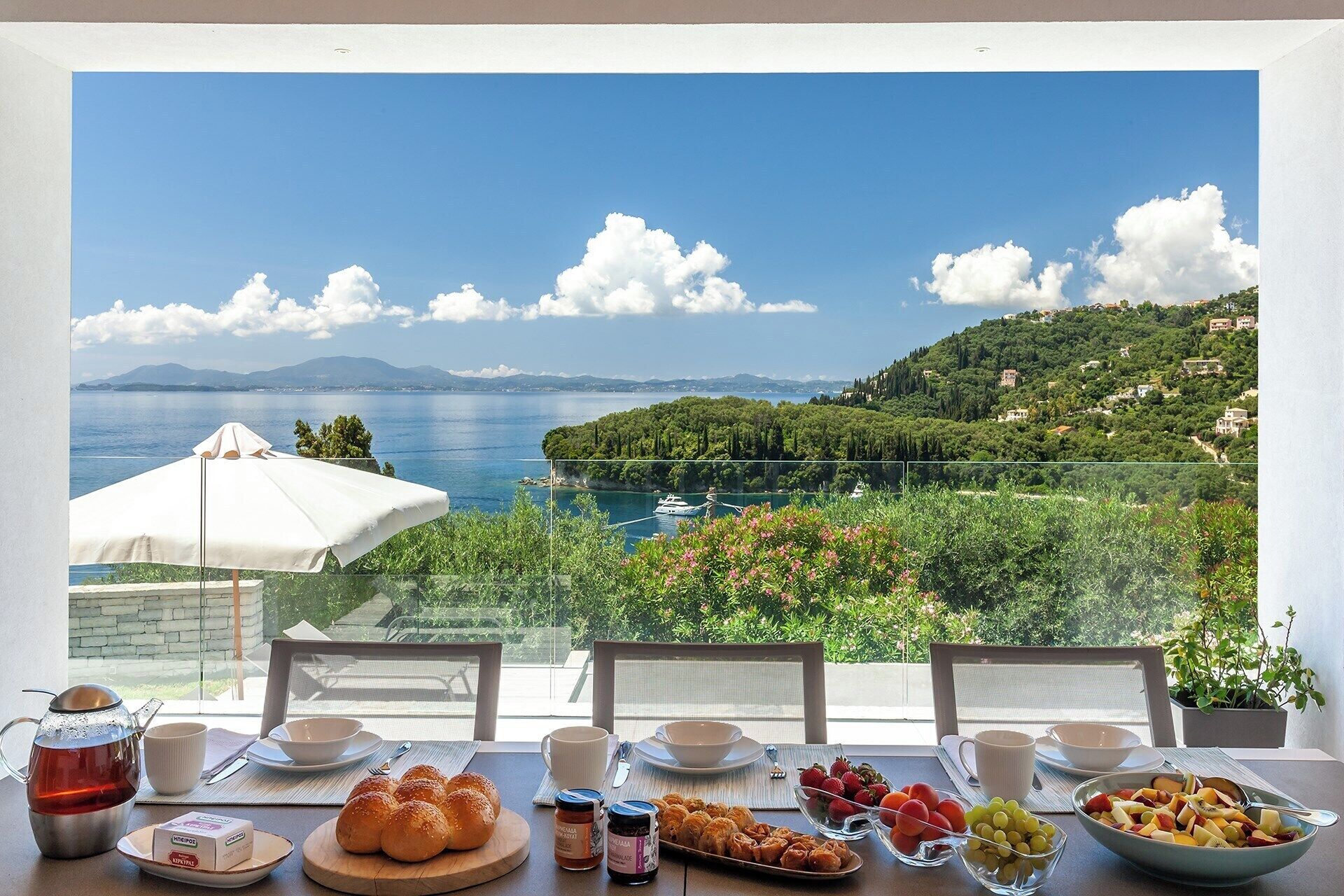 A table set for breakfast with a scenic view of a coastal landscape.