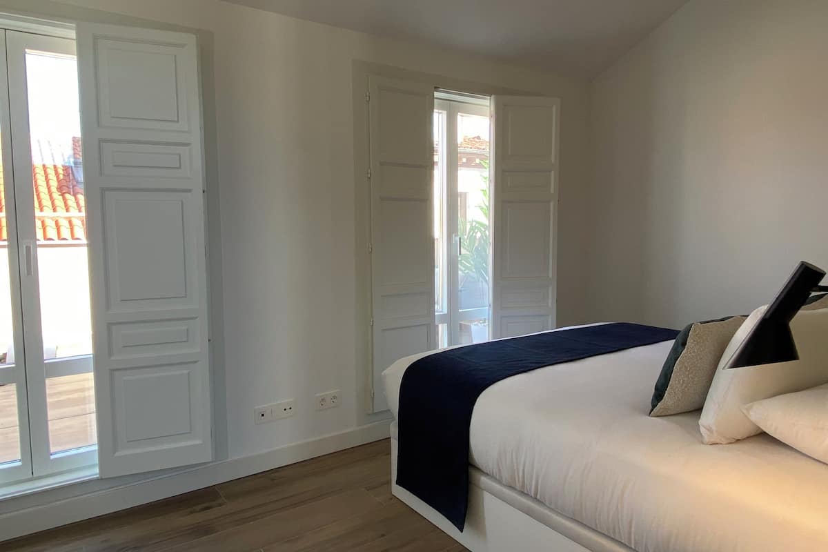 Una camera da letto con un letto, una finestra e una porta.