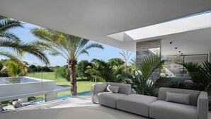 Ein modernes Wohnzimmer mit großem Fenster, das einen Pool und viel Grün zeigt.