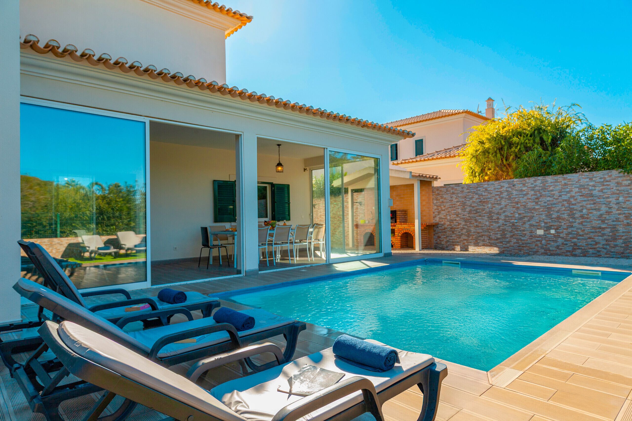 A swimming pool with lounge chairs and a patio area.