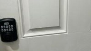 Une porte blanche avec un clavier de code situé sur le côté gauche.