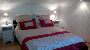 A neatly made bed with a patterned bedspread, two pillows, and two bedside lamps.