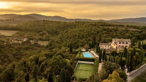 Une villa entourée d’une végétation luxuriante et dotée d’un court de tennis.