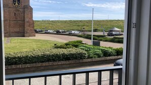 Une vue d’une zone de stationnement avec un beffroi en arrière-plan.