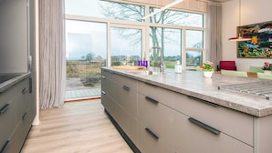 Eine moderne Küche mit großem Fenster, Backofen und Spüle.