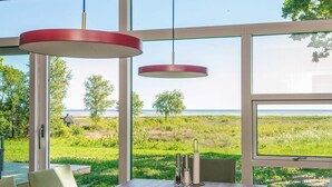 Ein Essbereich mit einem Holztisch, Stühlen und hängenden roten Pendelleuchten.