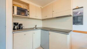 A compact kitchen with a microwave, coffee maker, and a sink. - T. de Pentrez Ndeg75 - 2P4 (Saint-Nic)