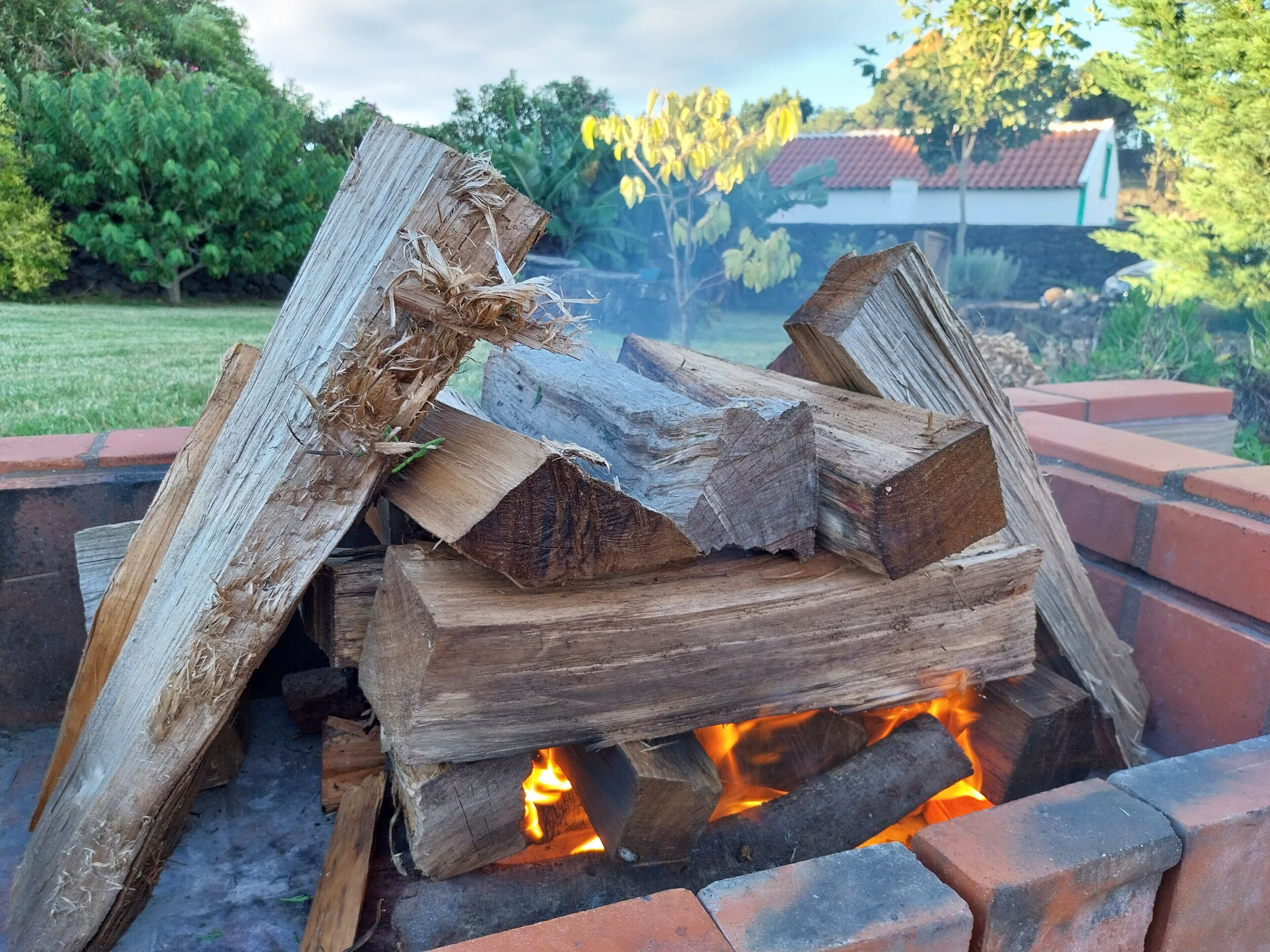 A fire pit with logs, surrounded by a brick structure.