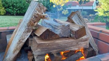 A fire pit with logs, surrounded by a brick structure.