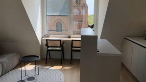 A small, modern kitchen with a dining area and a large window overlooking a brick building. - Lodge With a Magnificent View of the Dunes (Zoutelande)