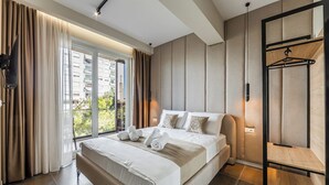 A modern hotel room with a large bed, a view of the city, and a wooden shelf. - Zoe's Villa by PS (Durrës)
