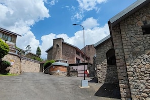 A stone building with a flat roof, a paved area in front, and a street lamp. - Mountain Club Resort (Chinnakanal)