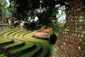 A terraced garden with a brick wall and a curved pathway. - Mountain Club Resort (Chinnakanal)
