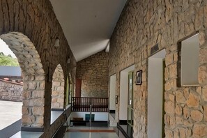 A stone-walled corridor with a staircase leading to an upper level. - Mountain Club Resort (Chinnakanal)
