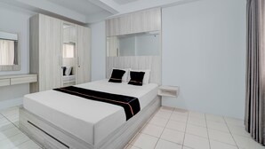 Een moderne slaapkamer met een groot bed, een inbouwkast en een spiegel boven het bed.
