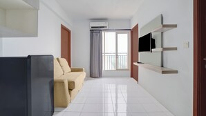 Een moderne woonkamer met een bank, een flatscreen televisie en een inbouwplank.