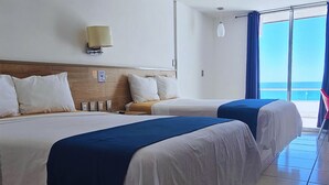 A hotel room with two beds, a large window with a view, and a ceiling fan. - Hotel Playamar (Mazatlán)