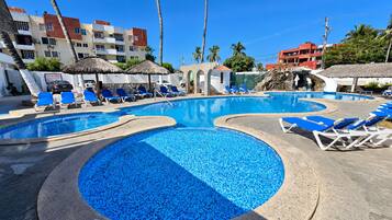 A pool area with multiple pools and lounge chairs.