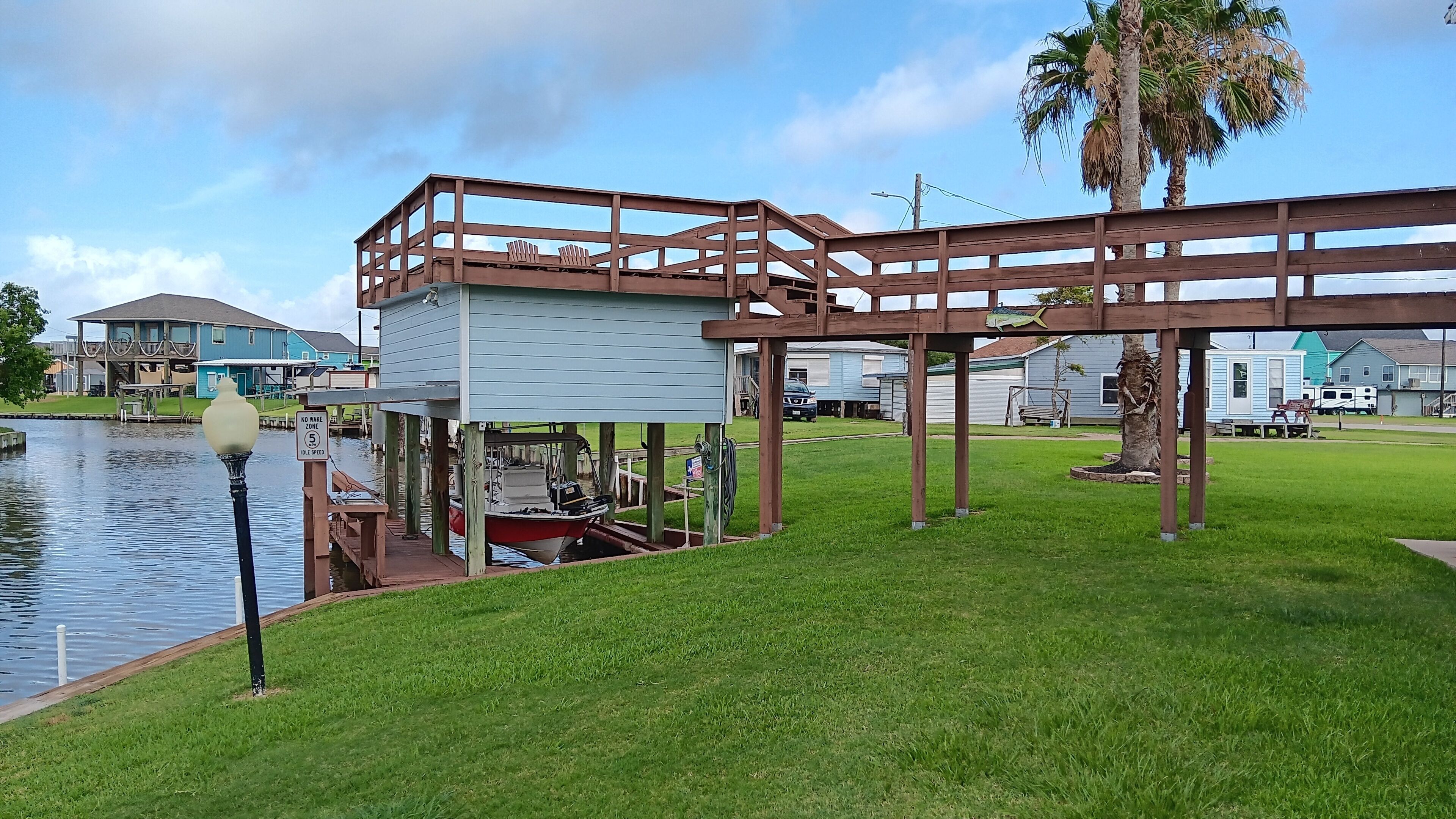 A waterfront property with a dock, a boat, and a gazebo structure.