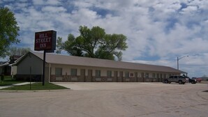 A motel with a sign reading "Hill Street Inn" and a row of rooms with a brick facade. - Hill Street Inn (Osmond)