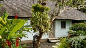 A house with a tiled roof, a garden with a tree, and a pathway leading to the house. - Villa Inka Ubud by Nakula (Bali)