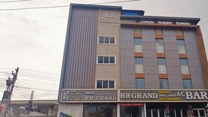 Ein mehrstöckiges Gebäude mit der Beschilderung 'RR GRAND' und 'A/C BAR'.