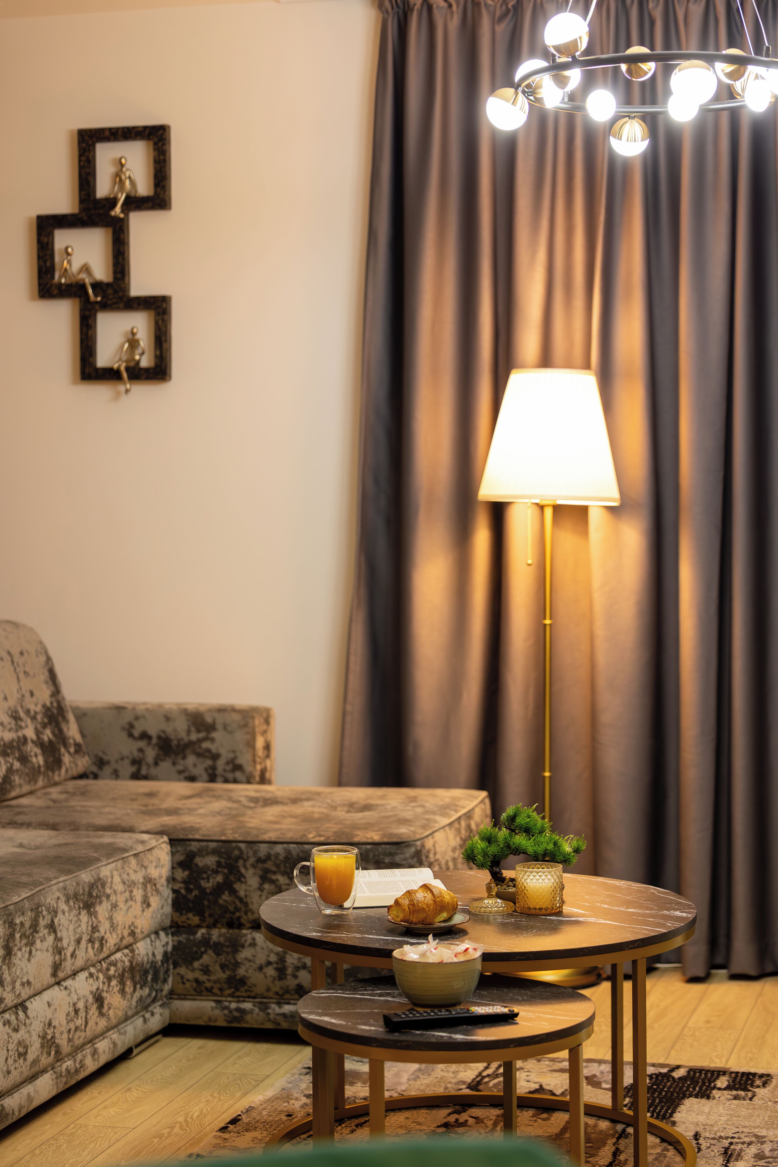 A cozy living room with a sofa, a round coffee table, and a lamp.