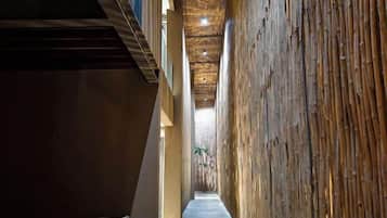 A corridor with a wooden wall and a ceiling with a woven pattern.